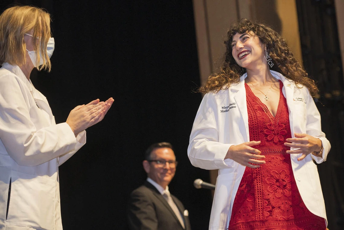 UArizona College of Medicine – Phoenix Associate Dean of Student Affairs Stephanie Briney, DO, applauds after giving Maya Khalil her white coat at the college’s Class of 2026 white coat ceremony.