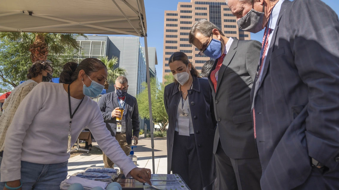 UArizona President Robert C. Robbins, MD, (right) and Mexican Ambassador to the U.S. Esteban Moctezuma Barragán (second from right) examine displays at the U.S. Mexico Binational Health Leadership Summit health fair on the Phoenix Biomedical Campus.