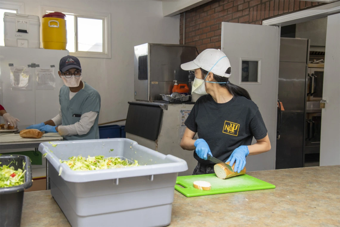 Koustubh Kandapalli and another student prepare meals to distribute to Tucson’s homeless population as part of the College of Medicine – Tucson’s Commitment to Underserved People program.