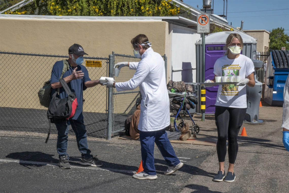 Medical students in the College of Medicine – Tucson serve food and beverages while offering health care to Tucson’s homeless population as part of the College’s Commitment to Underserved People program.