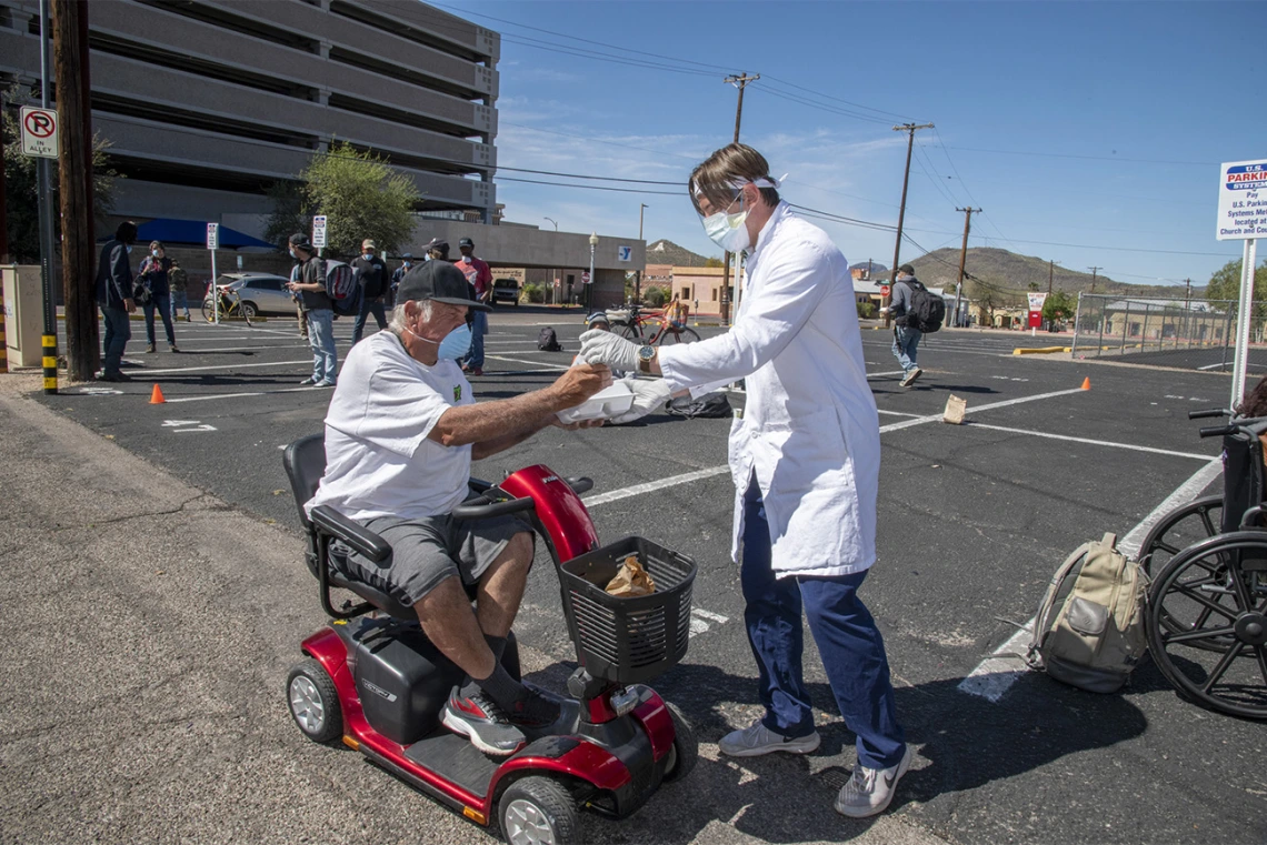 Students in the College of Medicine – Tucson distributed food, water and medical care to the homeless population in downtown Tucson during the pandemic. Pictured here in April near the Z Mansion, a food distribution site for the homeless population several times a week.