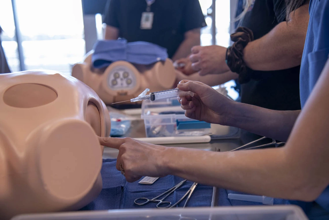 Students practice chest tube insertion during  intensive clinical skills training at ASTEC. 