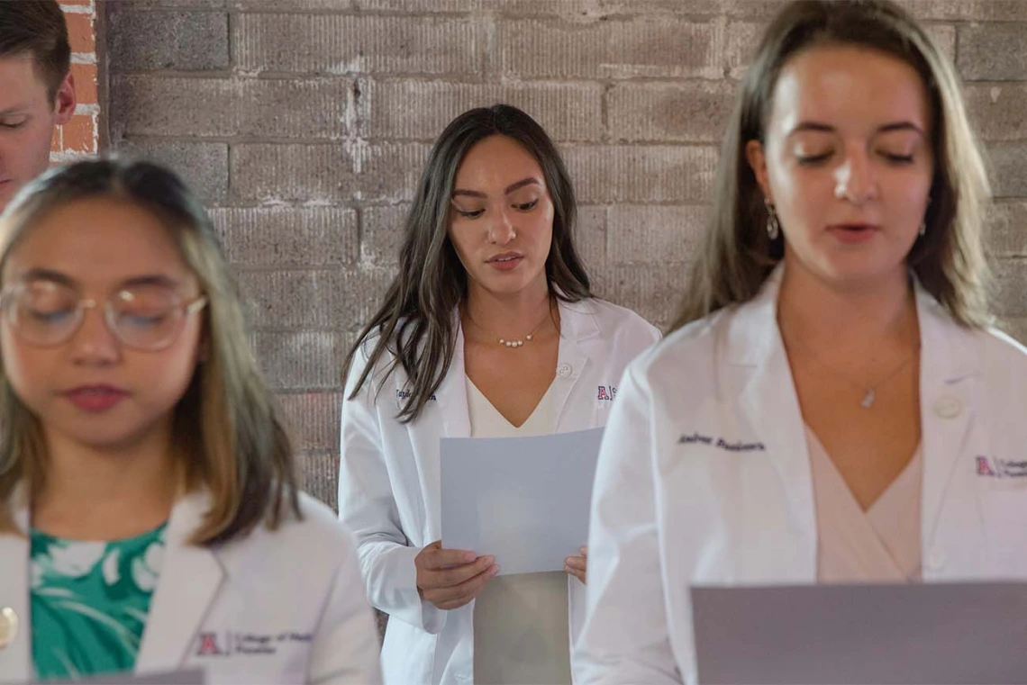 Fran Buranday, Taylor Elinski and Andrea Busicescu recite the oath along with the rest of their class during the ceremony.