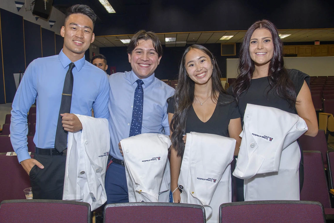 Medical students Brandon Zhang, Luis Novelo Hernandez, Nicole Kummet, and Emily Dereskiewicz pose for a photo before the start of the Class of 2025 white coat ceremony at Centennial Hall.