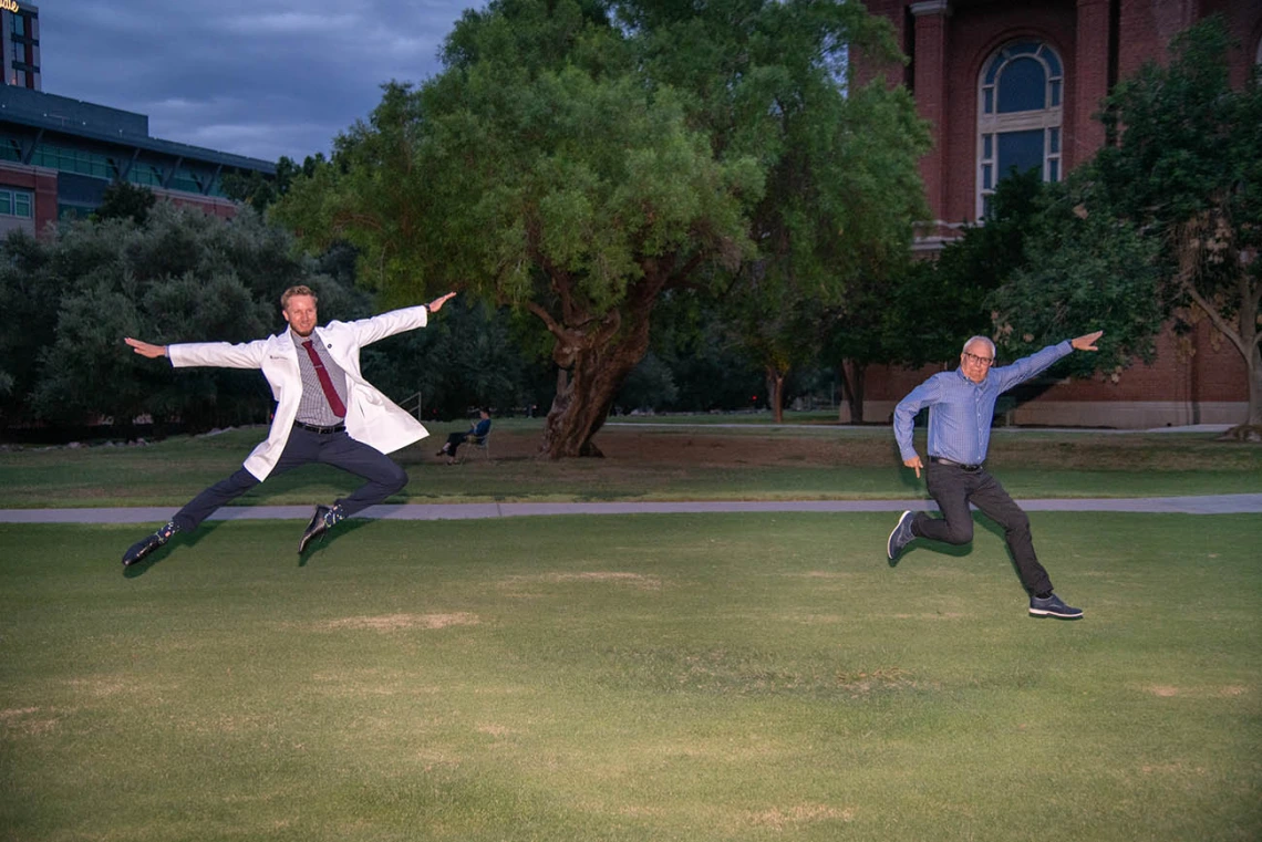 Medical student Matthew Flowers and his father Clifford Flowers jump for joy after Matthew received his white coat at the ceremony.