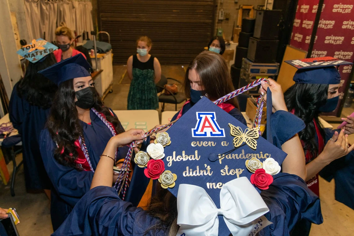 College of Nursing graduates prepare backstage at Centennial Hall before their commencement ceremony.