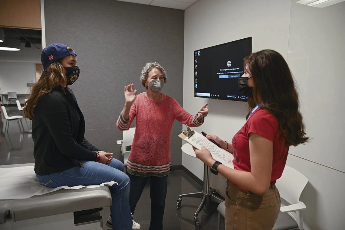 ACES camper Leia Switzer, left, had a chance to act as a patient while Ayleen Cruz, right, was the doctor during a simulated clinical skills rotation. Clinical skills volunteer patient, Claudia Orecka-Teplitsky, center, gave them feedback after they finished their simulation.