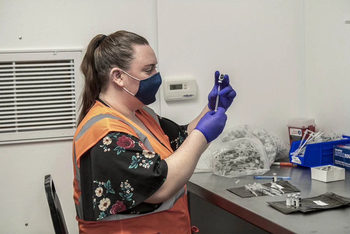 Hiller uses a syringe to measure 0.3 mL of the mixed Pfizer solution that will be given to patients at the University POD.