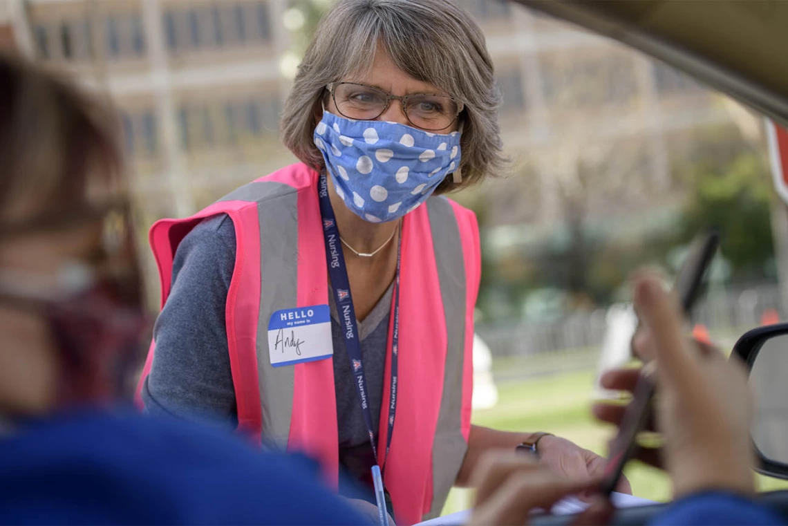 Volunteer Andy Fisher confirms vaccination appointments before drivers pull up to the vaccine distribution site.