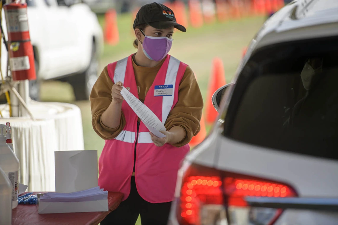 Mel and Enid Zuckerman College of Public Health graduate student Hannah Launius volunteers at the check-in area of the COVID-19 vaccination distribution site on the University of Arizona campus.