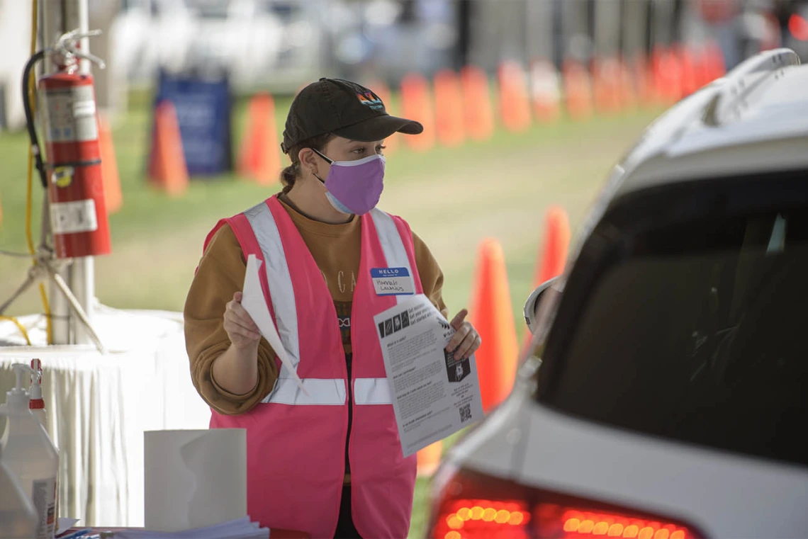 Mel and Enid Zuckerman College of Public Health graduate student Hannah Launius volunteers at the check-in area of COVID-19 vaccination distribution site.