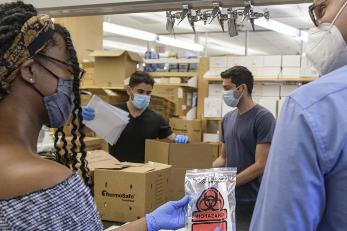 African-American student in lab working with professor on packaging testing kits.