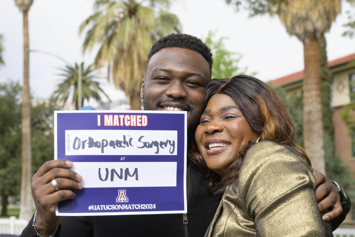 A fourth-year medical student from the University of Arizona College of Medicine – Tucson hugs his mom as he holds up a poster that says “I Matched.” 