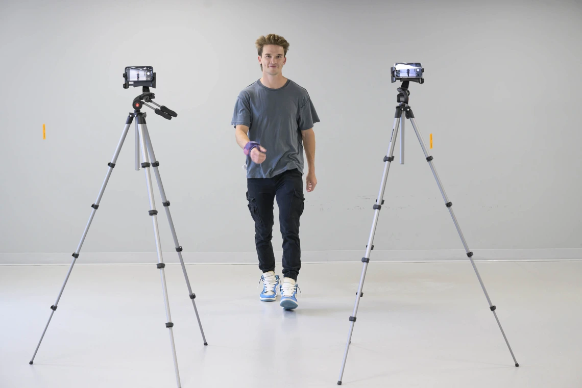 a study participant walking toward two cameras set up on tripods in an empty room at the University of Arizona Health Sciences