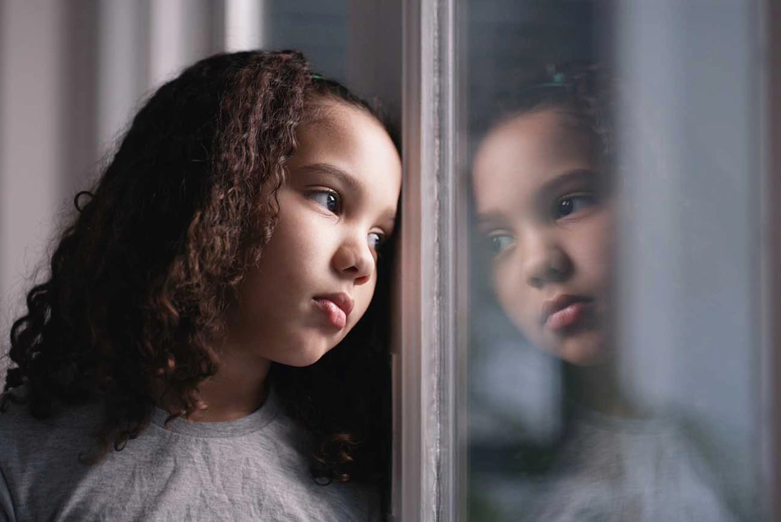 Girl looking out a window and thinking