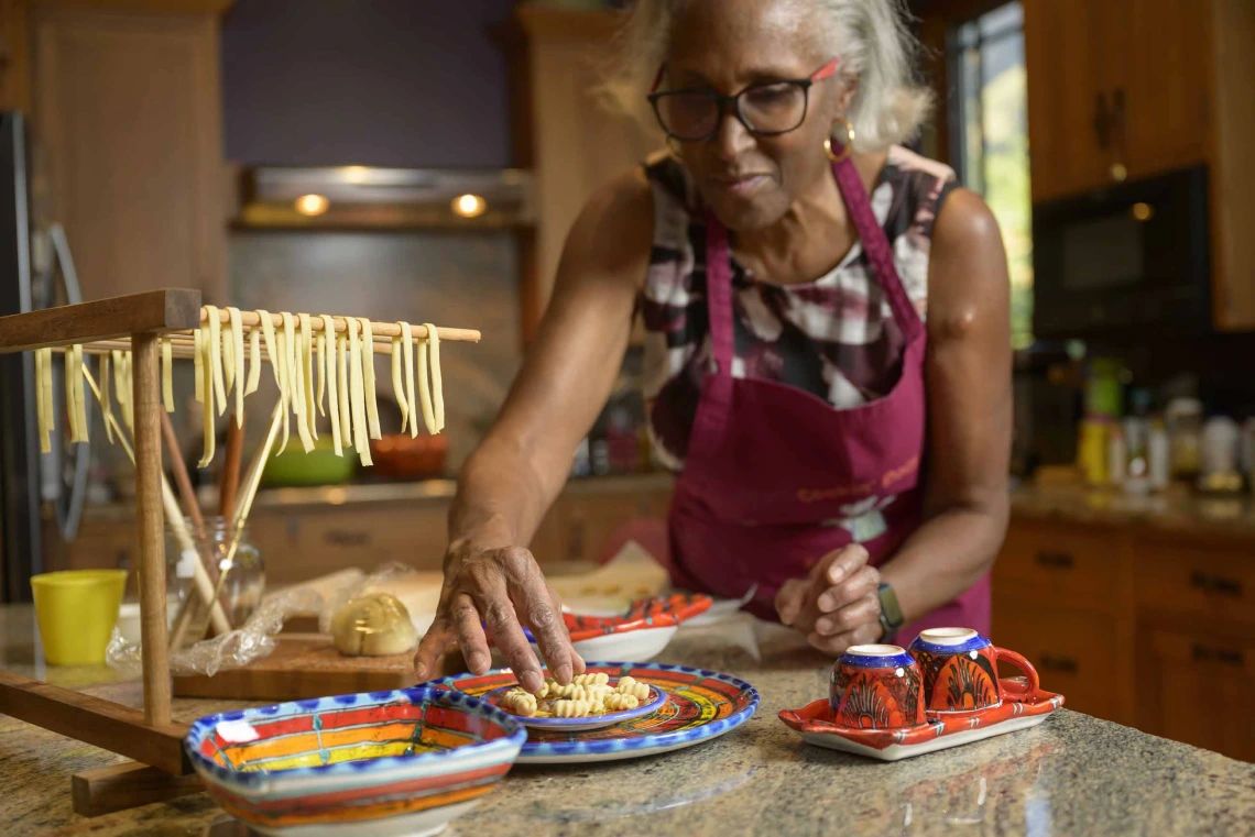 Dr. Juanita Merchant wears an apron as she makes a fresh pasta meal in her kitchen. 