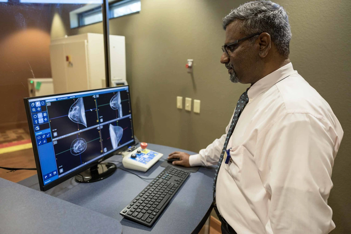 A man views CT images of breasts looking for signs of cancer