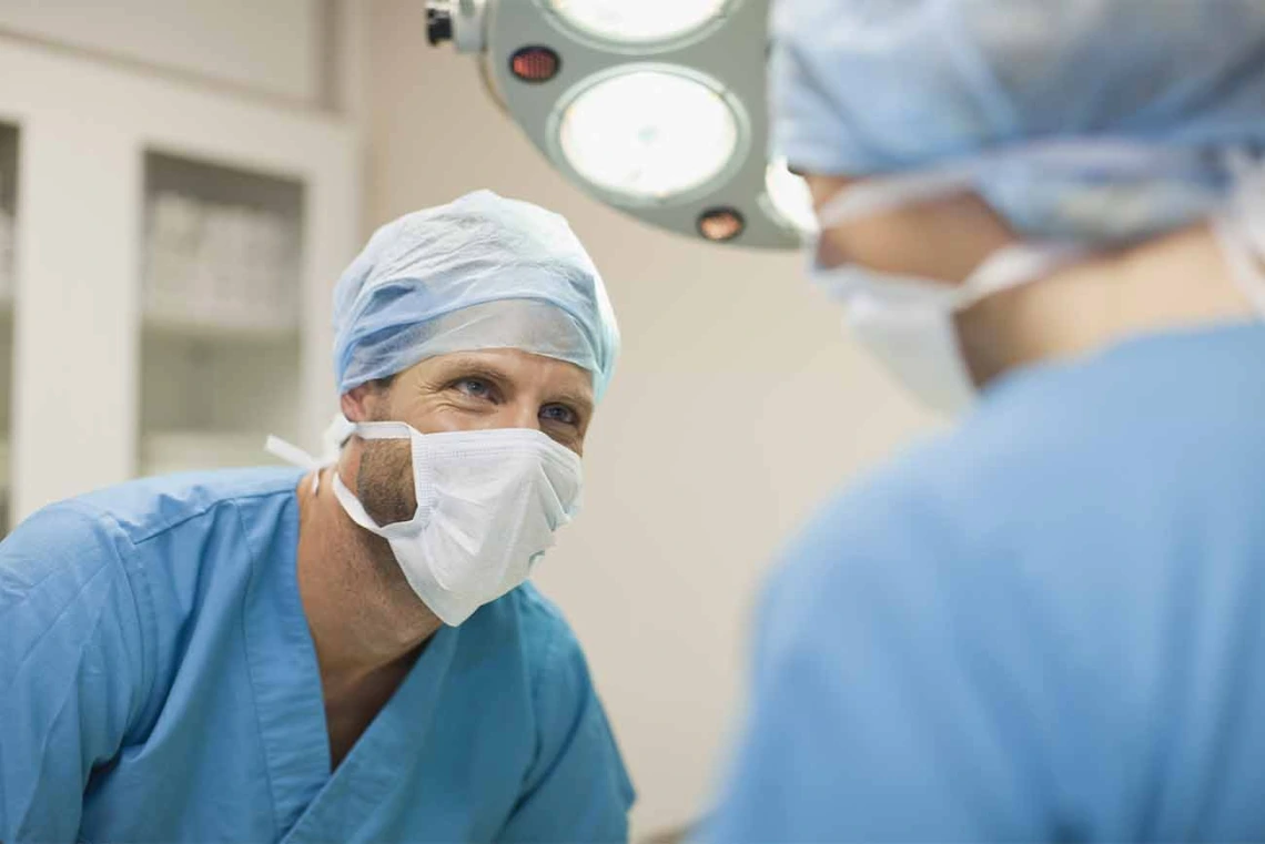 Doctor performing a surgery in a hospital with a physician assistant.