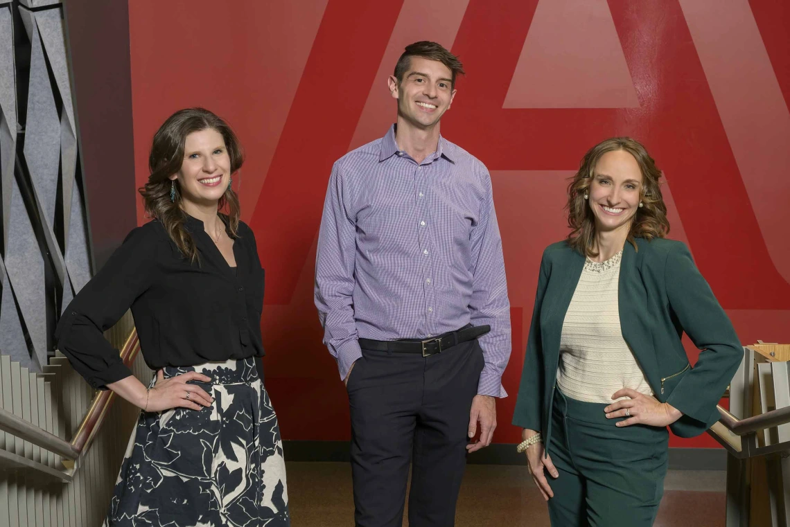 Portrait of Rina Fox, PhD, MPH; Nathan Lothrop, PhD; and Alaina F. Krone; standing next to each other in front of a University of Arizona logo.