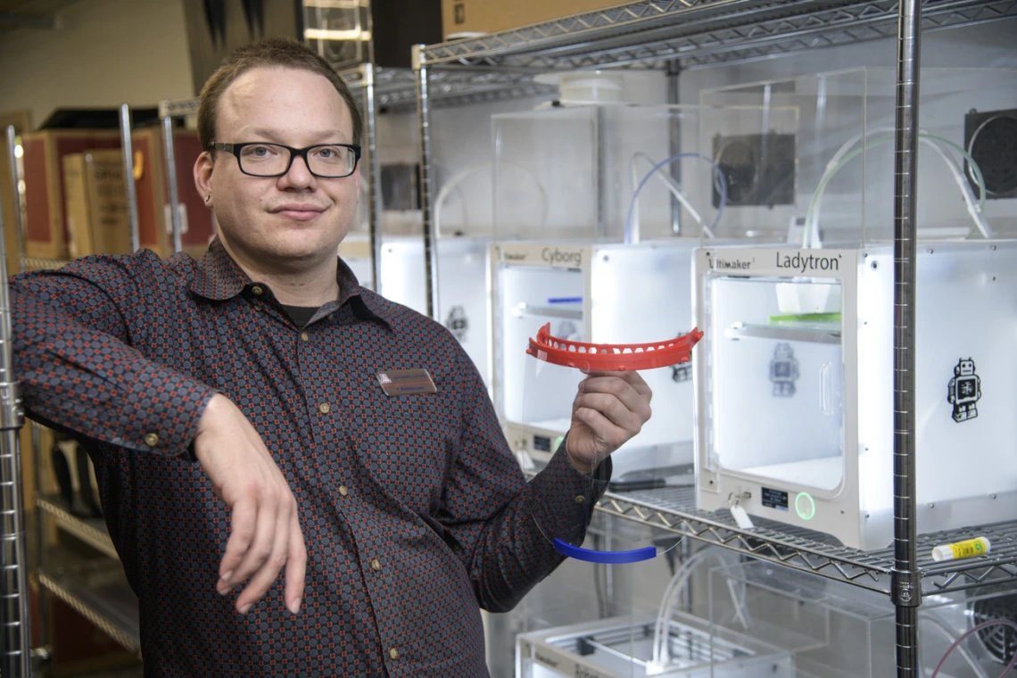 Tory Middlebrooks, of University Libraries, holds a face shield, which is designed to be worn with additional PPE such as a mask. Middlebrooks runs the 3D printers that produced the headbands for the face shields created by University of Arizona employees and students in makerspaces across campus. The effort was well underway by early April.