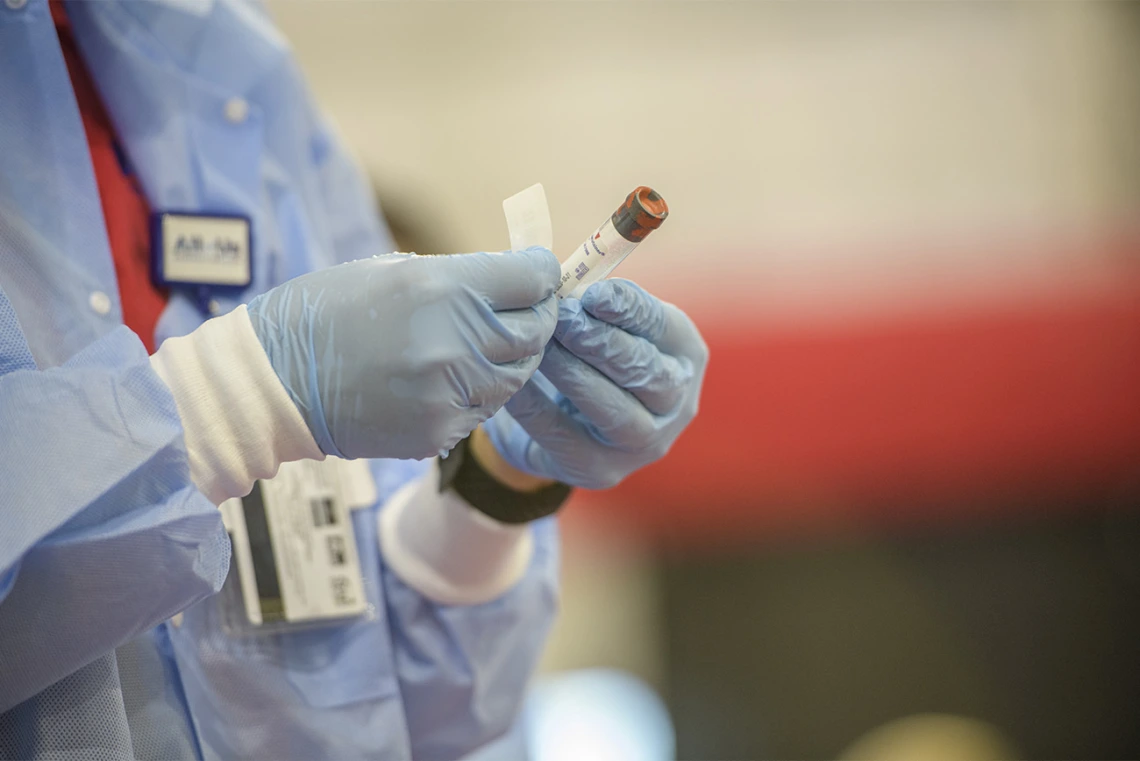 A health care worker labels a sample after collection.