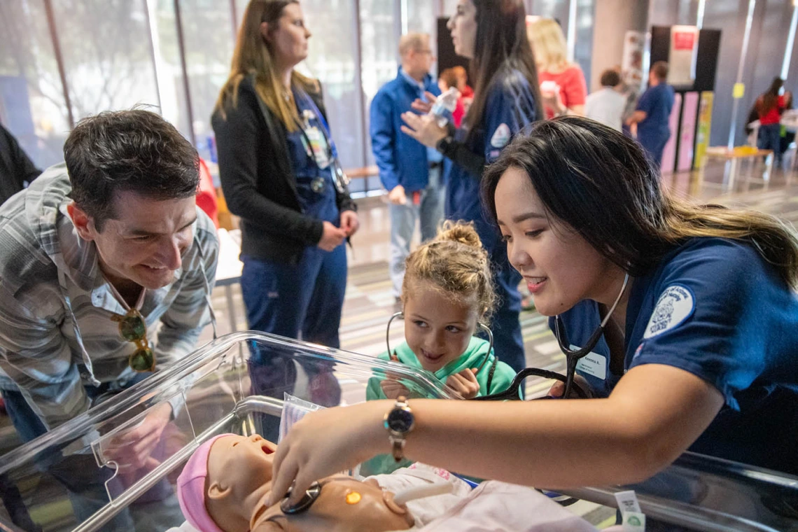 Volunteers from the University of Arizona College of Nursing check infant manikin for a heartbeat inside the Wildcat Play Hospital.