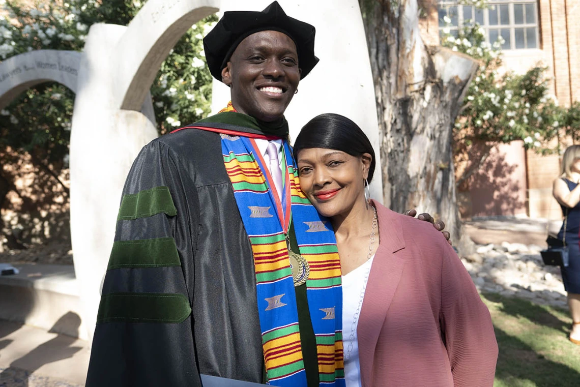 Caylan Bookman, MD, hugs his mother, Sheryl Williams, outside of Centennial Hall after the College of Medicine – Tucson class of 2022 convocation. 