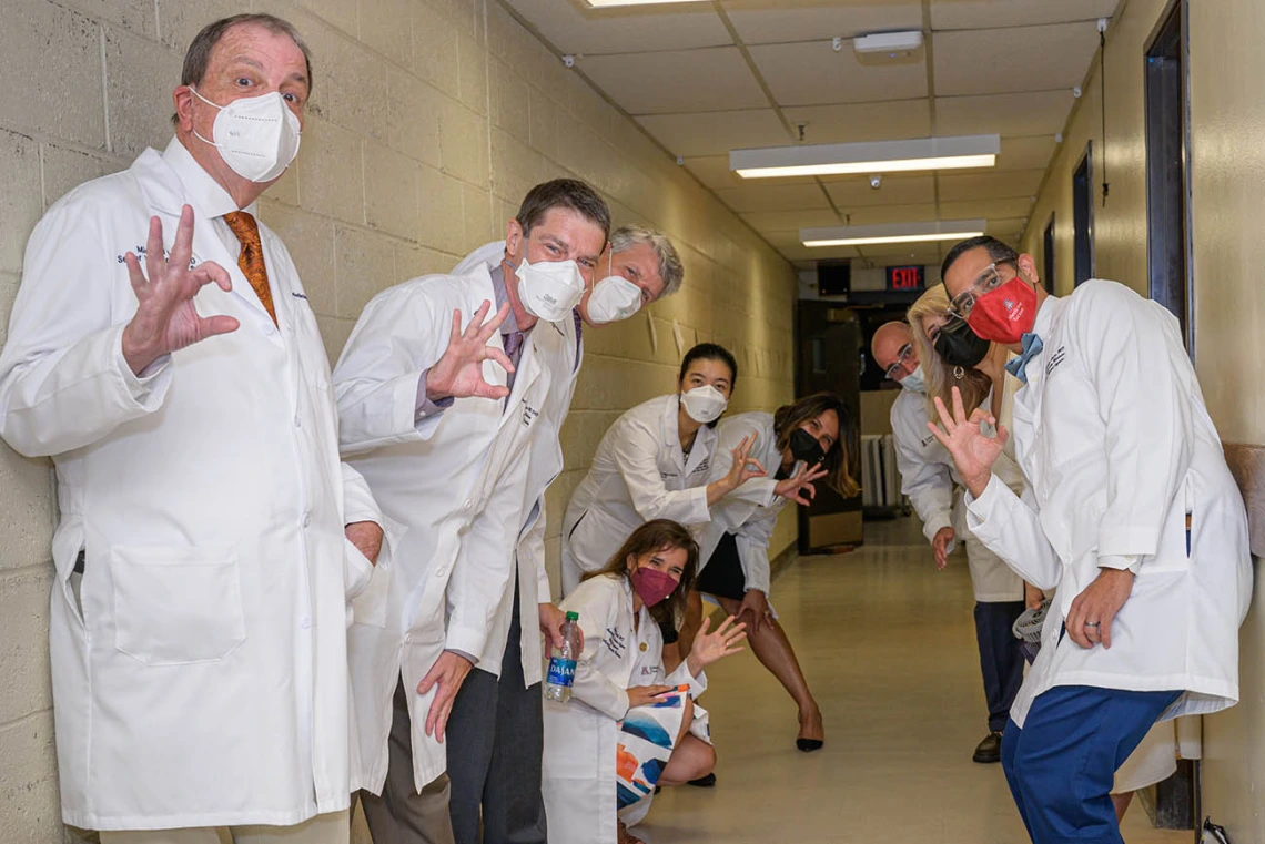 Michael D. Dake, MD, senior vice president for the University of Arizona Health Sciences (left) and UArizona College of Medicine – Tucson faculty members flash the Wildcat sign as they wait to go on stage at Centennial Hall for the Class of 2026 white coat ceremony.