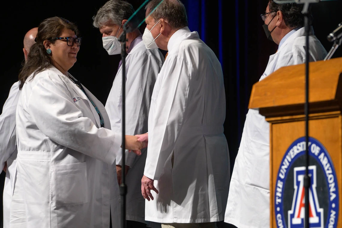 Nicole Bratsch is congratulated by Michael D. Dake, MD, senior vice president for UArizona Health Sciences, after receiving her white coat at the UArizona College of Medicine – Tucson Class of 2026 white coat ceremony.