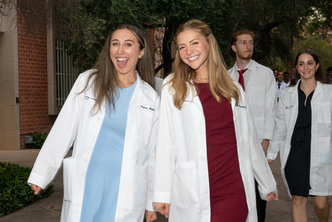 Dalia Alsbiei and Claire Rosenberger are all smiles as they leave Centennial Hall after the UArizona College of Medicine – Tucson Class of 2026 white coat ceremony.