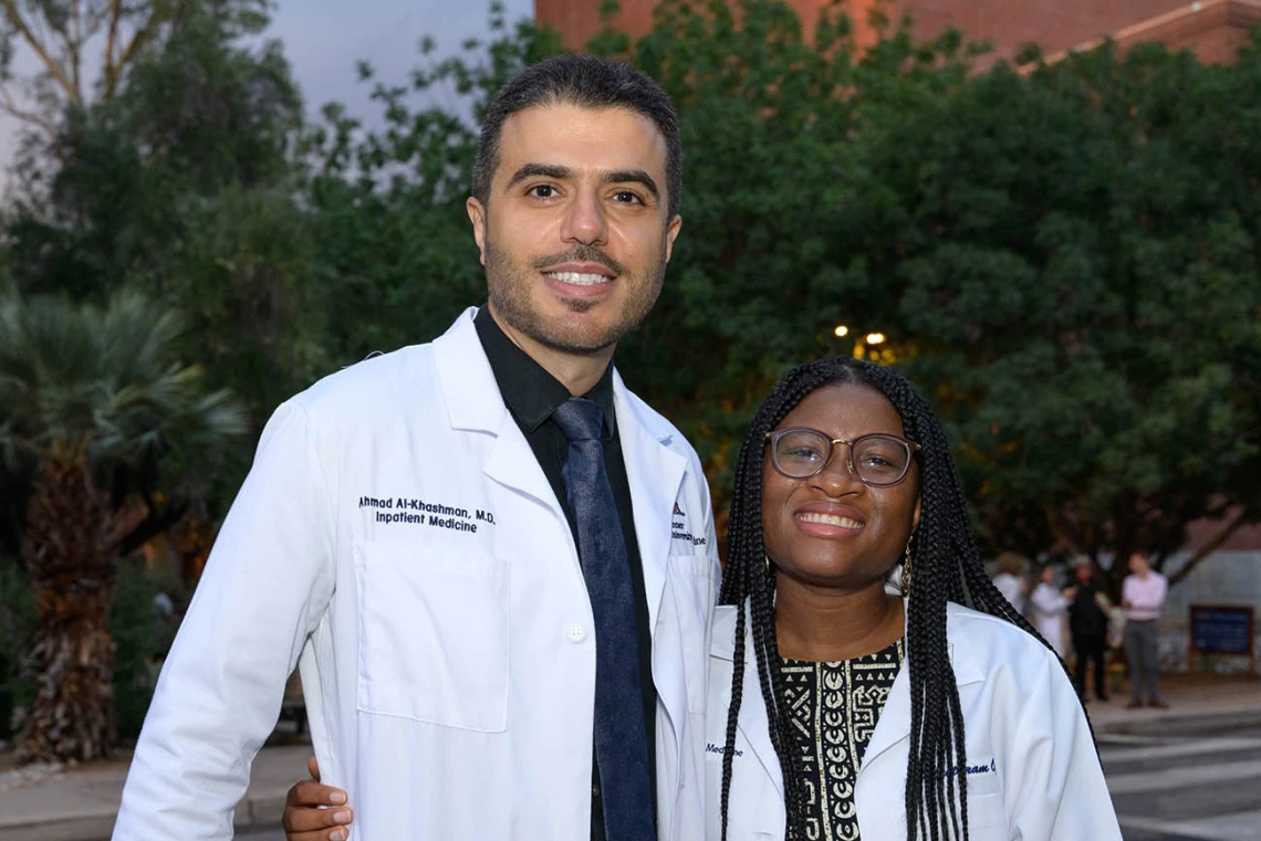 Assistant professor Ahmad Al-Khashman, MD, pauses for a photo while congratulating Chizitaram (Vanessa) Ogbuji after she received her white coat at the UArizona College of Medicine – Tucson Class of 2026 white coat ceremony.