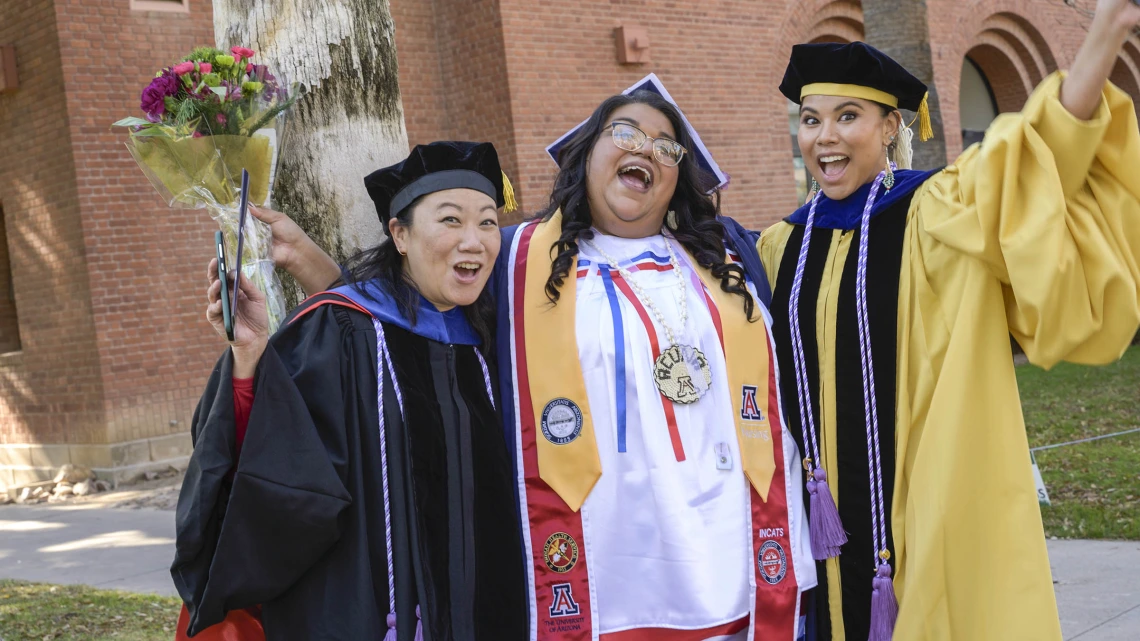 Assistant clinical professors Sharon Hom, PhD, MS, RN, (left) and Timian Godfrey, DNP, APRN, FNP-BC, (right) celebrate with Angela Acuna, who completed her Bachelor of Science in Nursing degree.