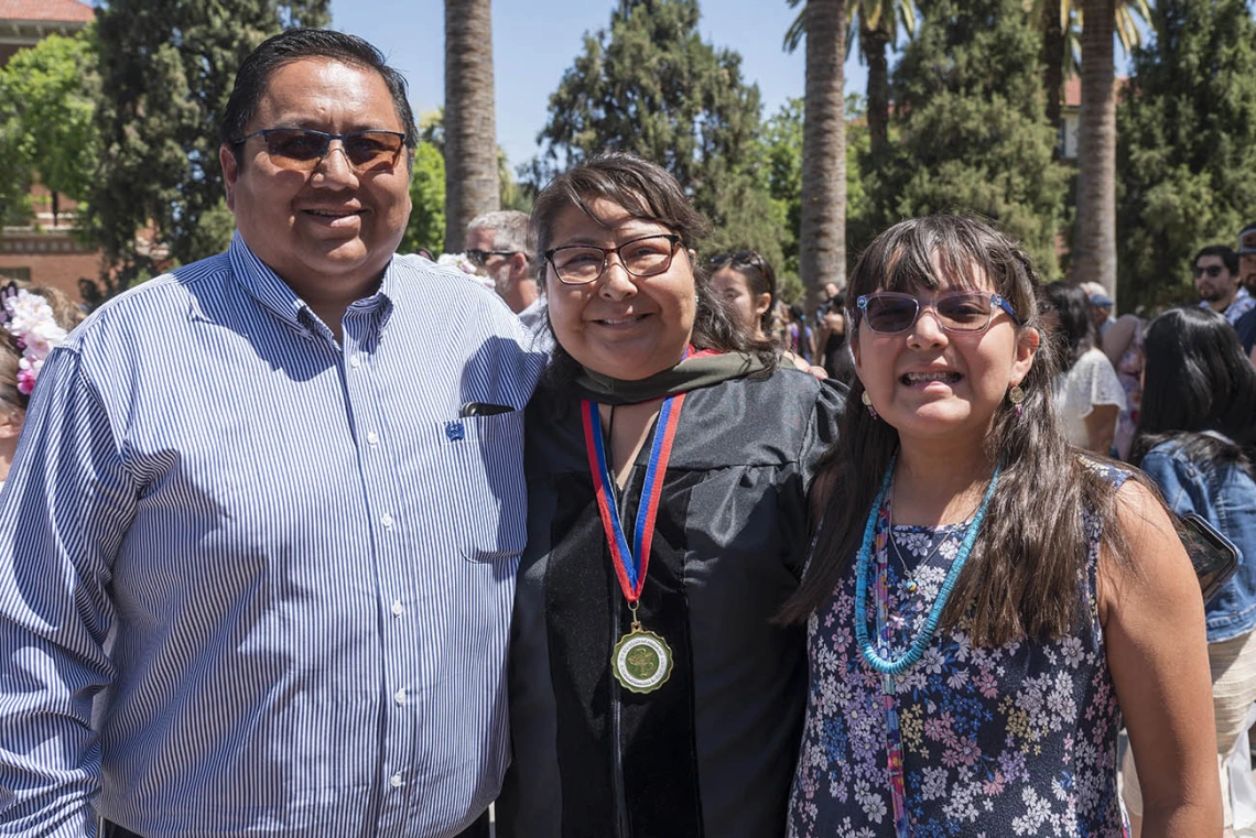 Desiree Smiley, PharmD, poses for a photo with her family after the R. Ken Coit College of Pharmacy 2022 spring convocation at Centennial Hall.