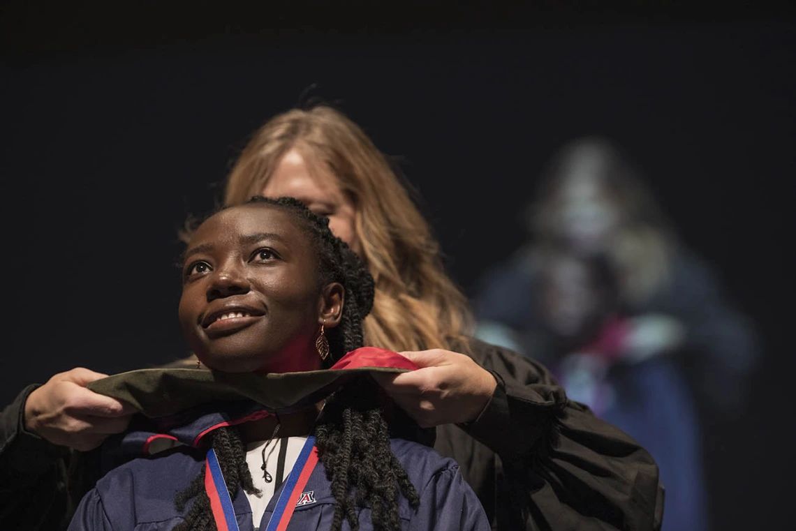 Mavis Obeng-Kusi, MSPS, is hooded by Terri Warholak, PhD, RPh, for earning her Master of Science in Pharmaceutical Sciences during the R. Ken Coit College of Pharmacy 2022 spring convocation at Centennial Hall.