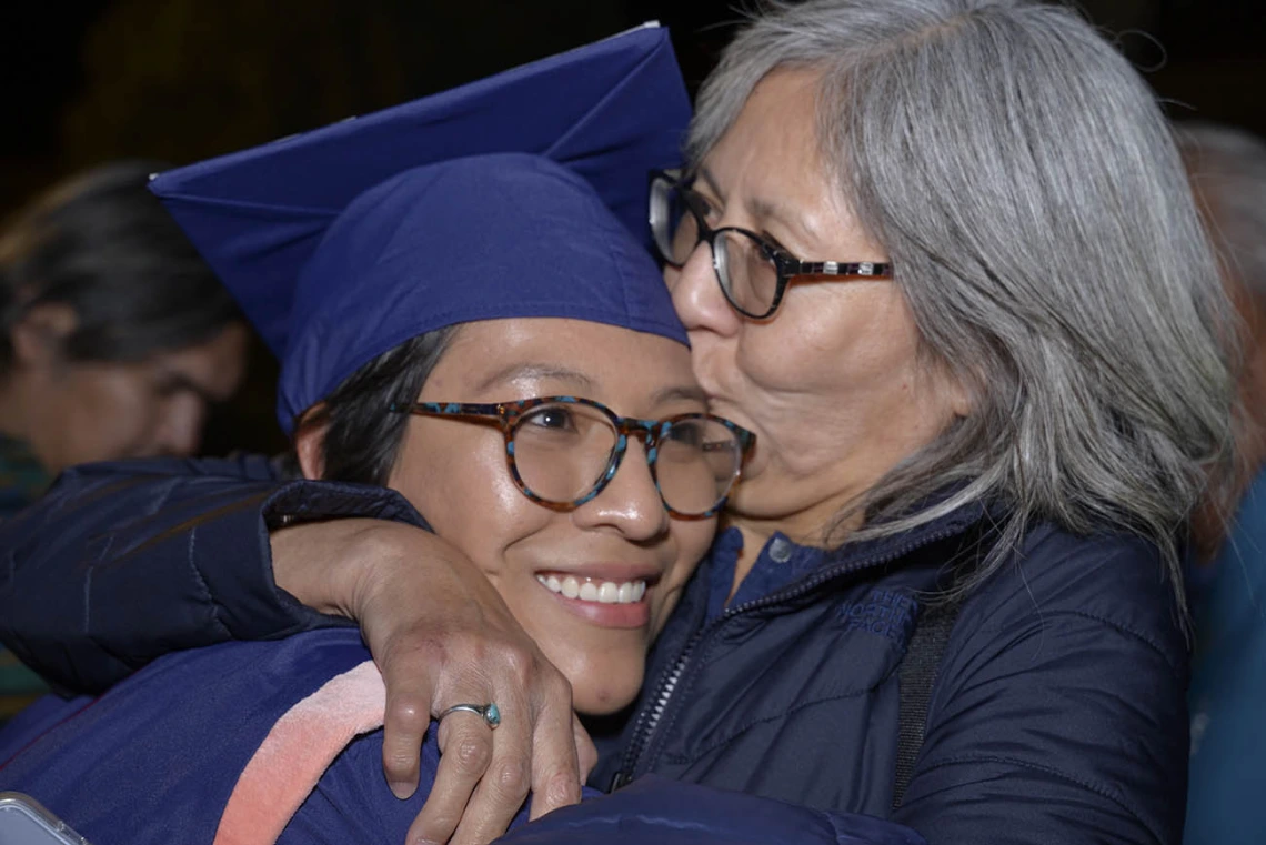 Breanna Lameman gets a congratulatory kiss from her mother, JoAnn Lameman, after receiving her Master of Public Health diploma at the Mel and Enid Zuckerman College of Public Health fall convocation.