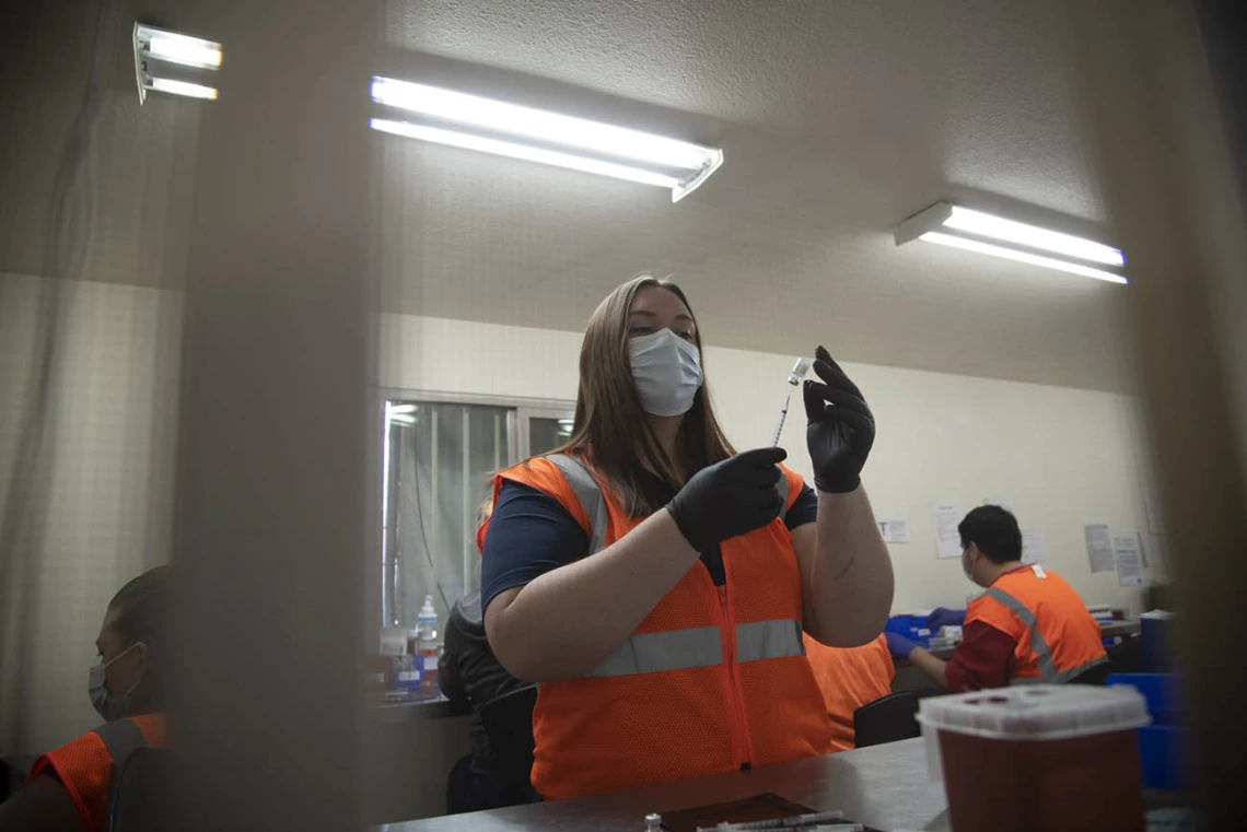 College of Pharmacy fourth-year PharmD student Annie Hiller prepares doses of the Pfizer vaccine, which will soon find their ways into the arms of recipients.