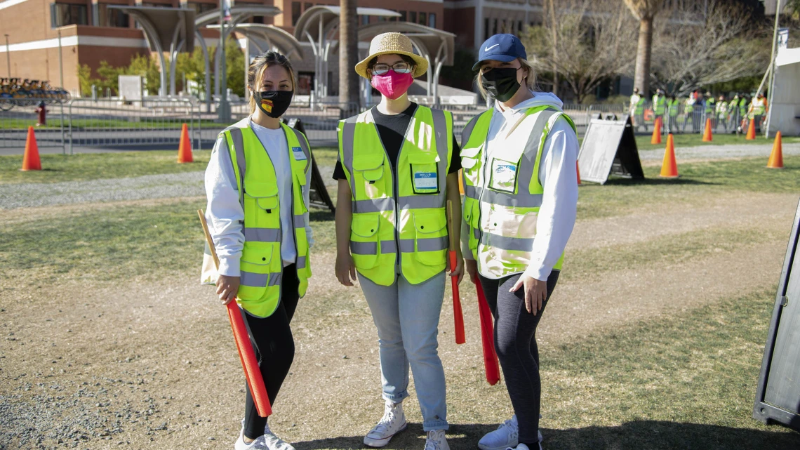 UArizona Health Sciences students Rebecca Lynn Amador, Ashley Casarez and Dariana Fimbres volunteer as traffic directors at the UArizona Point of Distribution in Pima County.