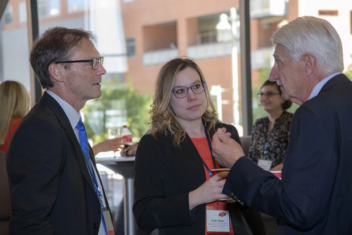 Don Kyle, PhD, CEO of the National Center for Wellness and Recovery at Oklahoma State University, and Kelly Dunn, PhD, executive director of the NCWR’s Addiction Treatment Center, chat with Frank Porreca, PhD, professor of pharmacology and principal investigator on the “Center of Excellence for Addiction Studies” grant, during a coffee break.