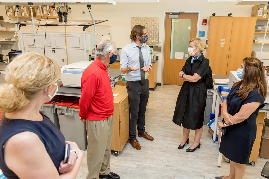 Deborah Birx, MD, coordinator of the White House Coronavirus Task Force, listens as Ryan Sprissler, PhD, staff scientist and manager of the UArizona Genetics Core, explains the antibody testing process. UArizona President Robert C. Robbins, MD, and others, joined Dr. Birx during her visit.