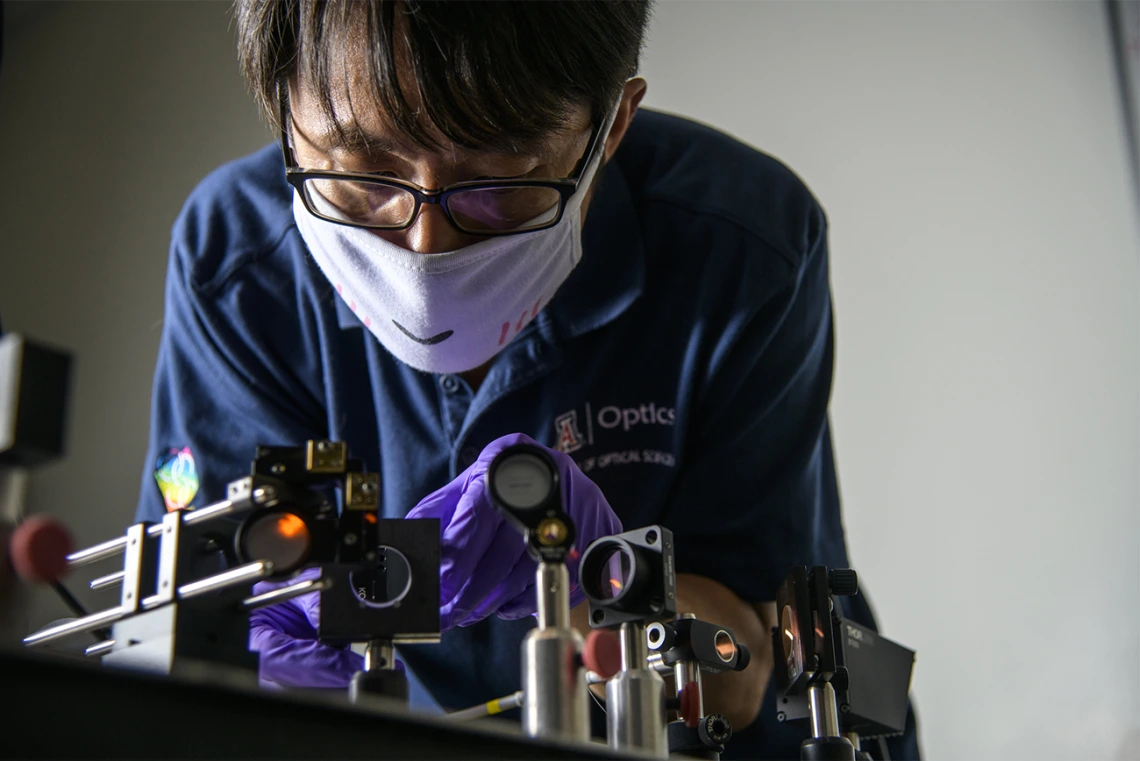 Dongkyun Kang, PhD, works to align the laser optics to increase the light power of a portable confocal microscope he is  developing with Clara Curiel-Lewandrowski, MD.