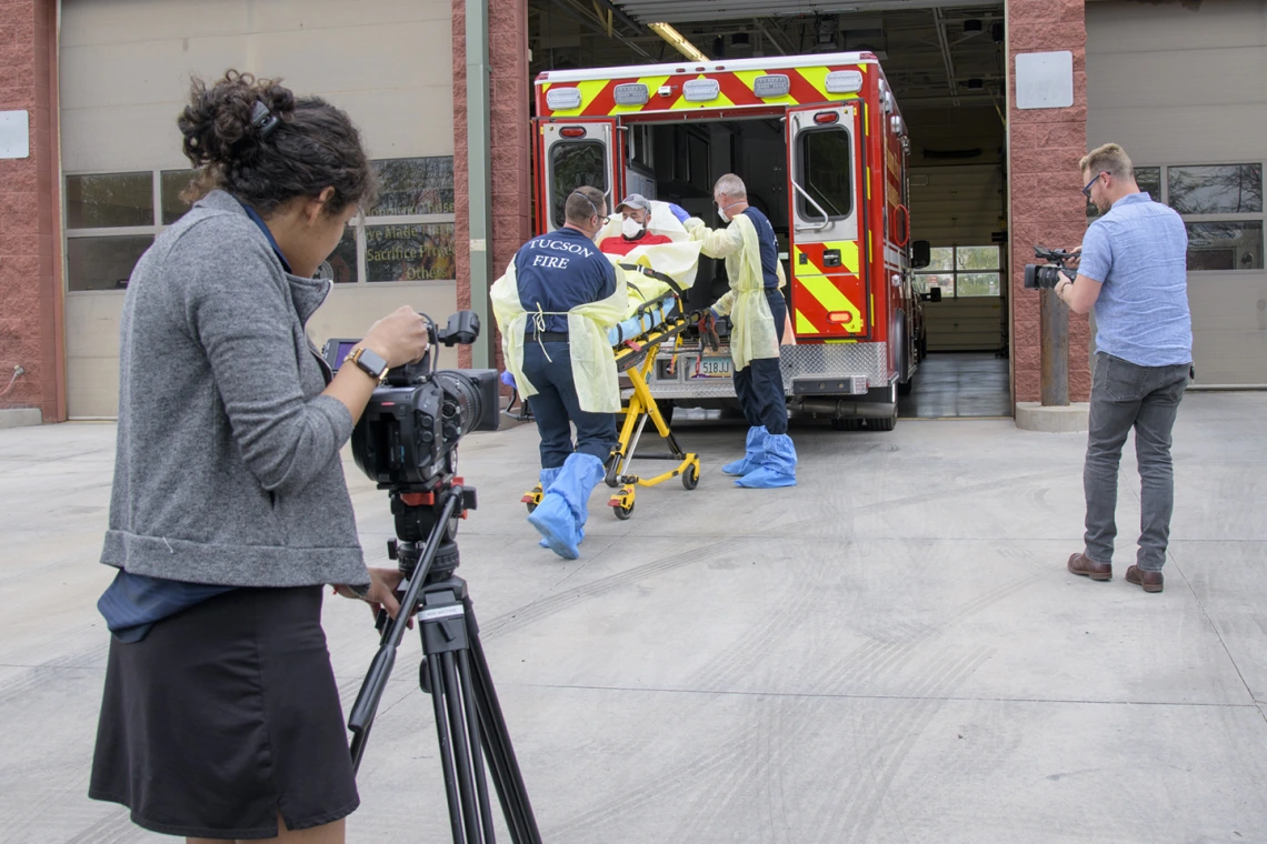 University of Arizona Health Sciences’ Viola Watson and Erich Healy document the loading of a patient into ambulance. Healy works for the Mel and Enid Zuckerman College of Public Health and the Western Regional Public Health Training Center.