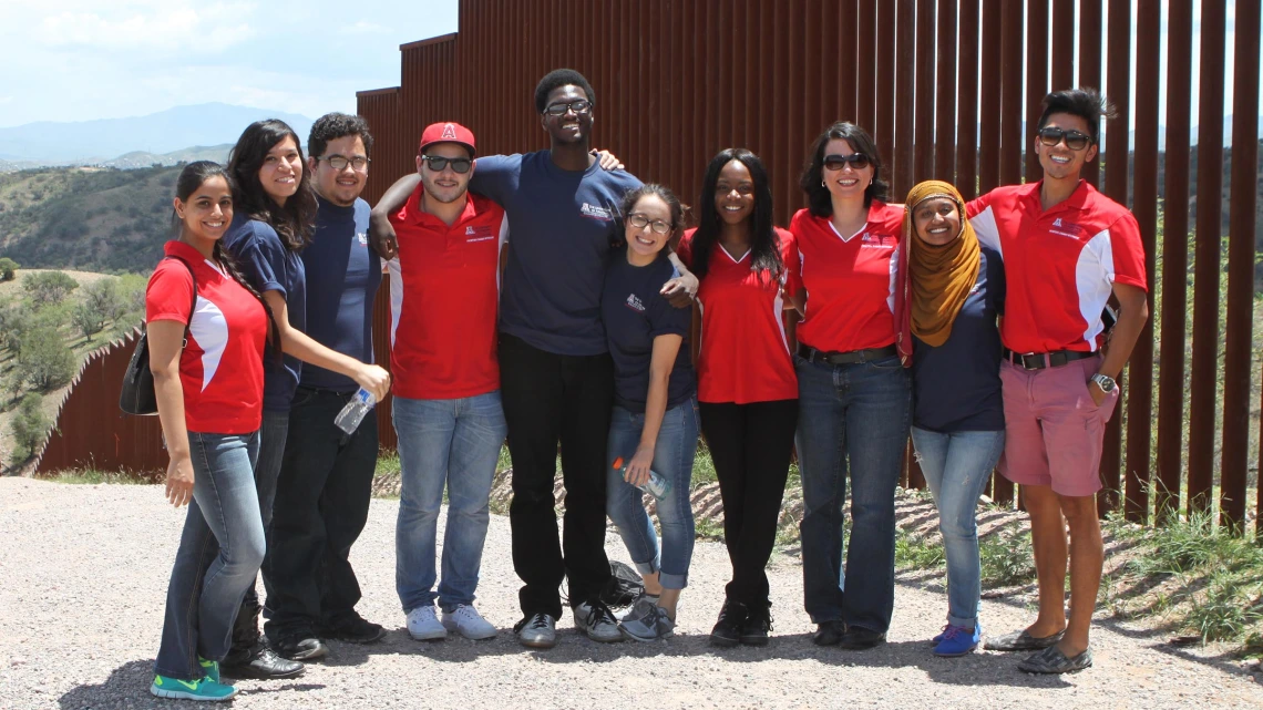 FRONTERA interns learn firsthand about the challenges affecting the U.S.-Mexico border region. Here, the 2014 cohort is pictured on a fieldtrip to the border wall. Ray Larez, MPH, is third from the left, and Alejandra Zapien Hidalgo, MD, MPH, is third from the right.