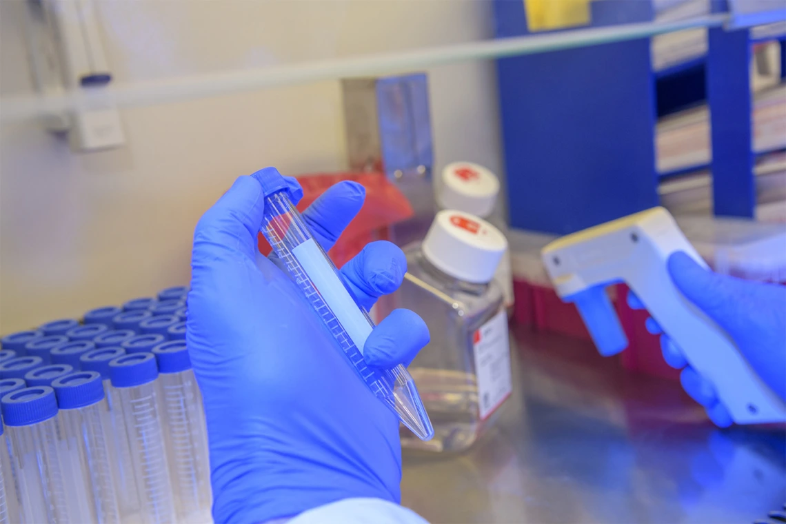 Michael Badowski, PhD, holds a test tube with a media in it for preserving COVID19 sample cells.