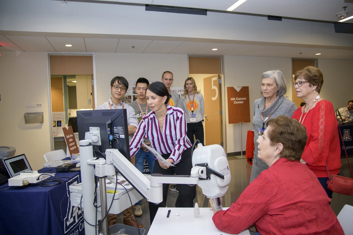 Clara Curiel, MD, teaches onlookers about skin cancer research on the eighth floor of the Health Sciences Innovation Building.