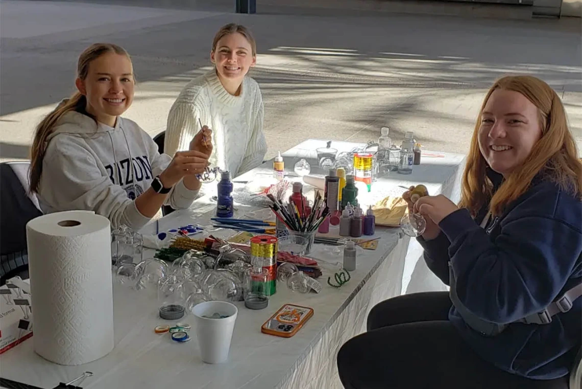 The R. Ken Coit College of Pharmacy Office of Student Services hosted an end of semester holiday party where (from left clockwise) Alex McDaniel, Reagan Blanchard and Jenna Harris, all pharmaceutical sciences undergraduate students, paint ornaments and decorate holiday cookies. 