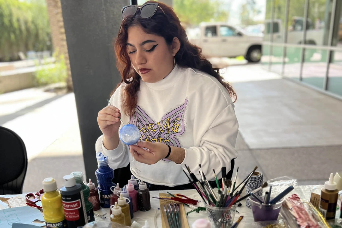 Aryanna Lozano, a pharmaceutical science undergraduate student in the R. Ken Coit College of Pharmacy, paints an ornament at an end of semester holiday party hosted by the College of Pharmacy Office of Student Services.