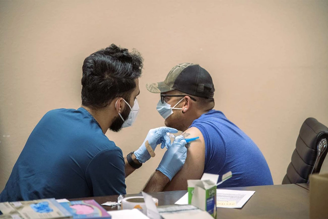 College of Medicine – Tucson senior Abdullah Aleem gives farm work supervisor Rubén Sosa a COVID-19 vaccine shot. The goal of MOVE UP is to promote more inclusive participation of rural and underrepresented groups in getting the vaccine among hard-to-reach populations in partnership with the UArizona Health Sciences, state and county health departments and other local partnerships.