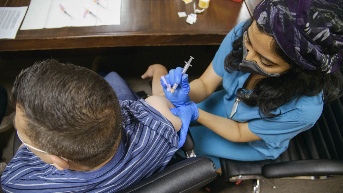 Maya Sarihan, MD, then a College of Medicine – Tucson 4th year medical student, administers a COVID-19 vaccine to an agricultural laborer at the Consulate of Mexico in Douglas, Arizona, as part of a MOVE UP clinic hosted by UArizona Health Sciences.