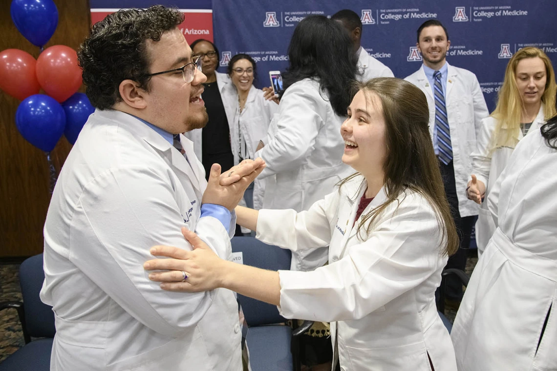 Primary Care Physician scholarship recipient China Rae Newman, right, congratulates fellow scholarship recipient Raymond Larez, MPH, after his speech at the Tucson scholarship reception. 