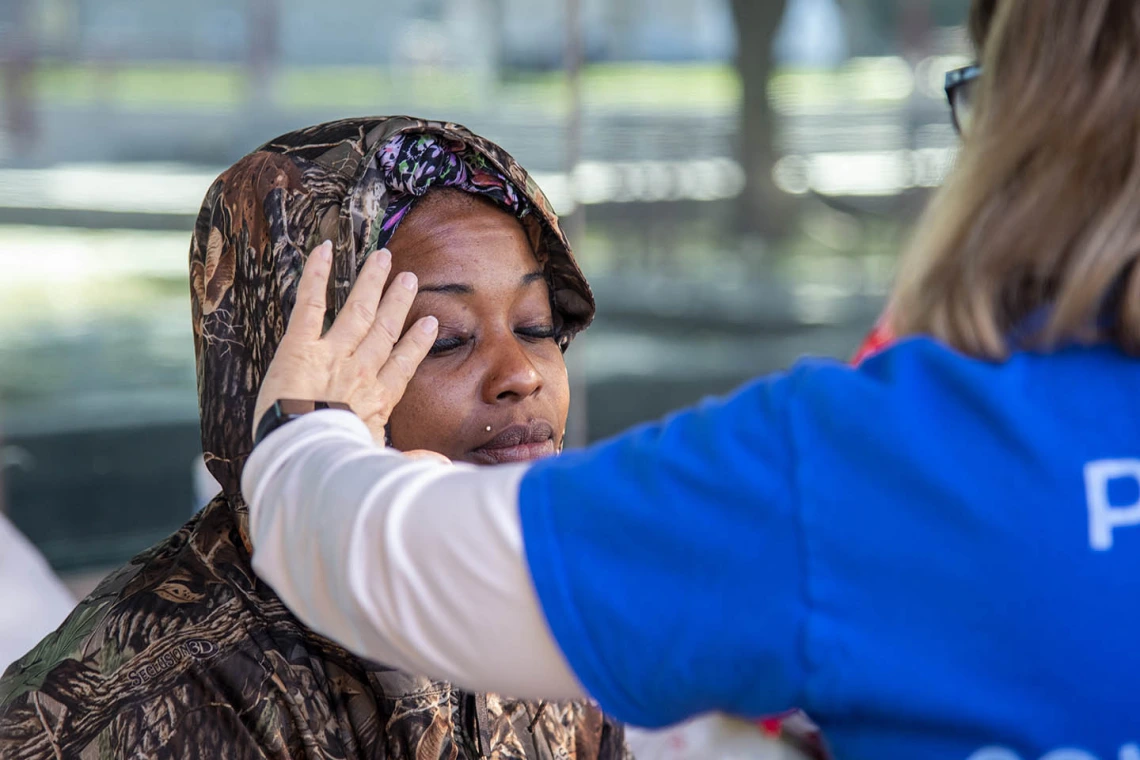 A Street Medicine Phoenix volunteer examines a woman seeking medical attention for a bump on her eye, which turned out to be a stye.